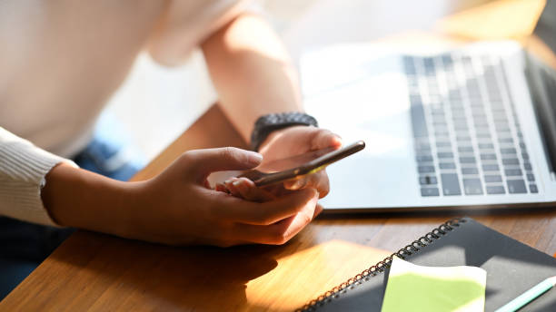 istock Close-up female holding her smartphone on workspace. 1205310461