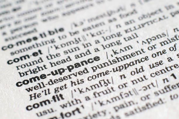 istock A close-up on a word Comeuppance in English dictionary (selective focus) 1205311092