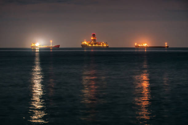 three cargo ships anchored in the open sea