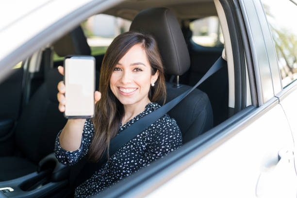 istock Smiling Beautiful Woman With Cellphone In Car 1205315169