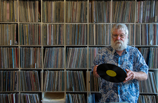 Record collector in front of his collection, looking at the camera
