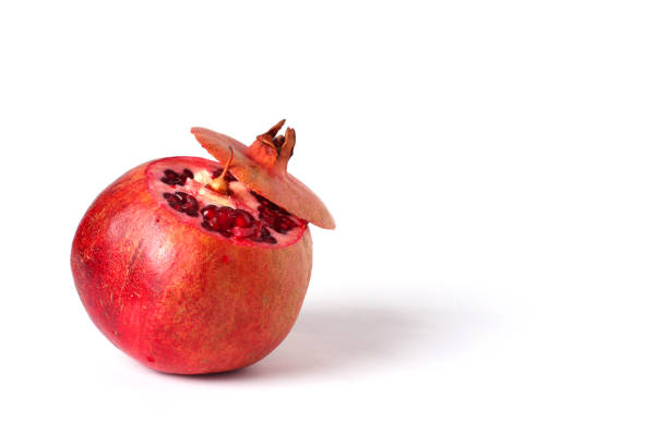 istock Ripe pomegranate fruit isolated on white background cutout. Pomegranate seeds. Pieces of pomegranate are scattered. Horizontal orientation. Copy space for text. 1205317606