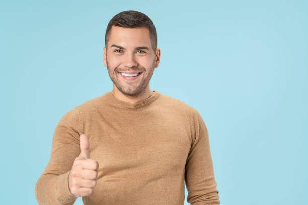 istock Cheerful handsome man showing thumb up isolated on blue background 1205326910