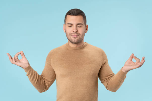 istock Concentrated relaxed man standing with closed eyes while meditating. Yoga and meditation concept 1205327081