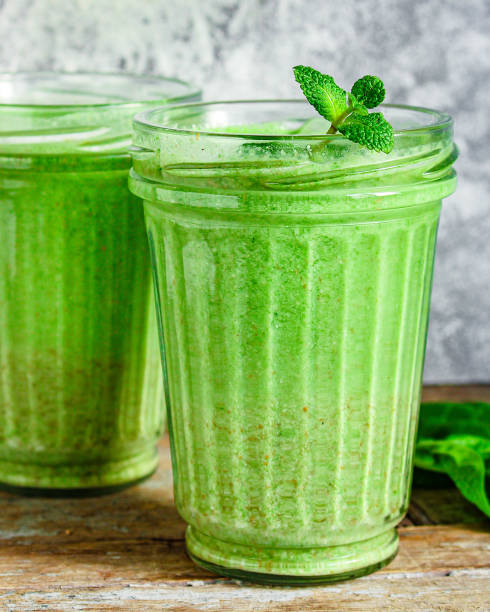 istock green smoothie cocktail antioxidant diet (organic fruit vitamins, vegetarian drink) menu concept background. top view. copy space 1205327308