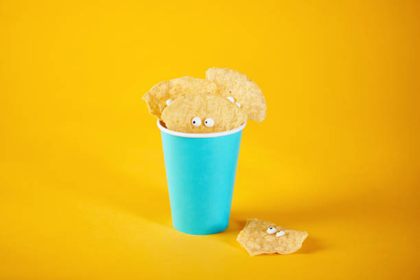 istock Tortilla chip characters in cup on yellow background 1205327637
