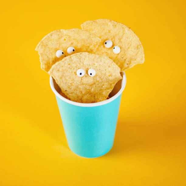 istock Tortilla chip characters in cup on yellow background 1205328290