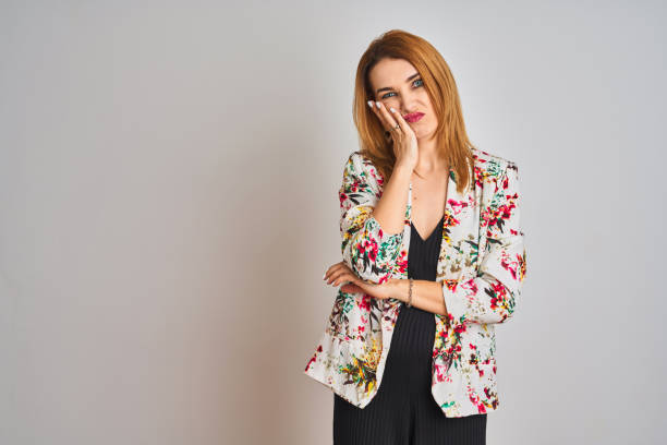 молодая кавказская бизнес-женщина в костюме весенней цветочной куртки на изолированном фоне мышления выглядит уставшей и скучной от пробл - life jacket despair business life стоковые фото и изображения