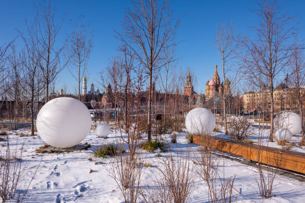 Moscow, Russia - February 8, 2020: View of the Moscow Kremlin, Ivan the Great Bell-Tower, Spasskaya tower and St. Basil's Cathedral from Zaryadye Park on sunny winter day. In the foreground Large ball-shaped lanterns.