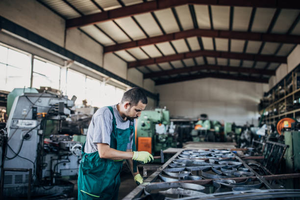 istock Young man working in metal factory 1205335626