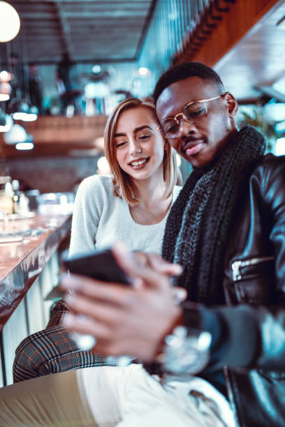 istock African Male Let's His Caucasian Girlfriend Push The Selfie Button 1205336741