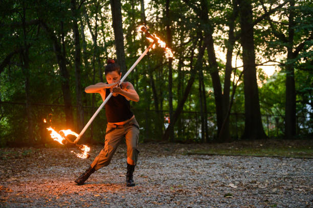This is a color photograph of a real woman practicing the art of Poi fire dancing in Atlanta, Georgia in southern USA.