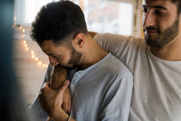 istock Young man kisses his partner hand affectionately 1205336945