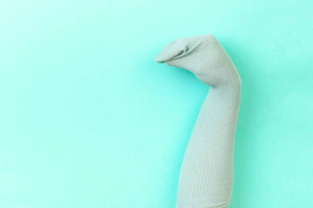 istock funny doll sock on blue background, hand theater 1205337122