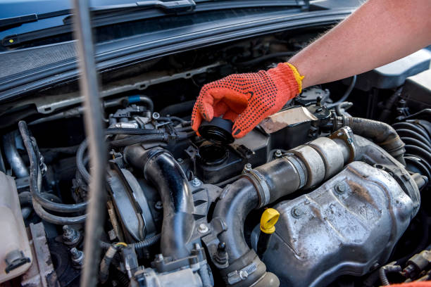 istock Hands in protective gloves with car engine close up. Car repair concept 1205337131
