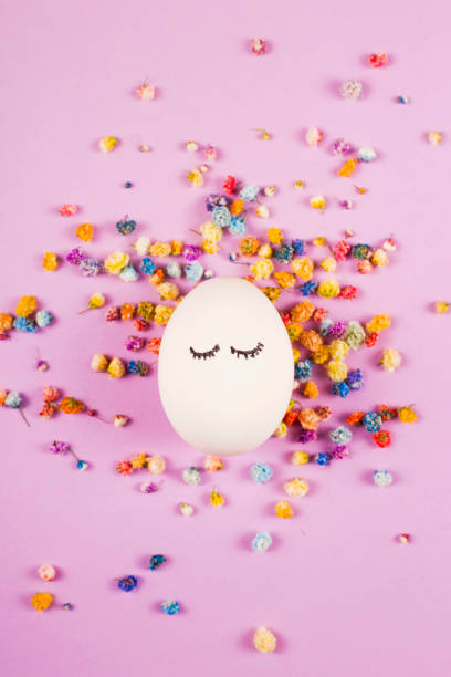 Portrait of an easter egg among flowers on purple.