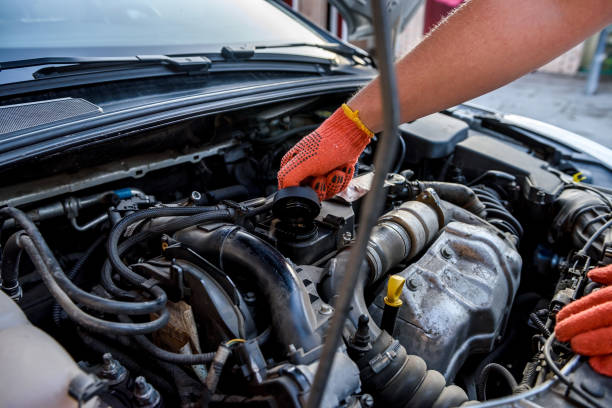 istock Human hands examining car engine in protective gloves close up 1205337684