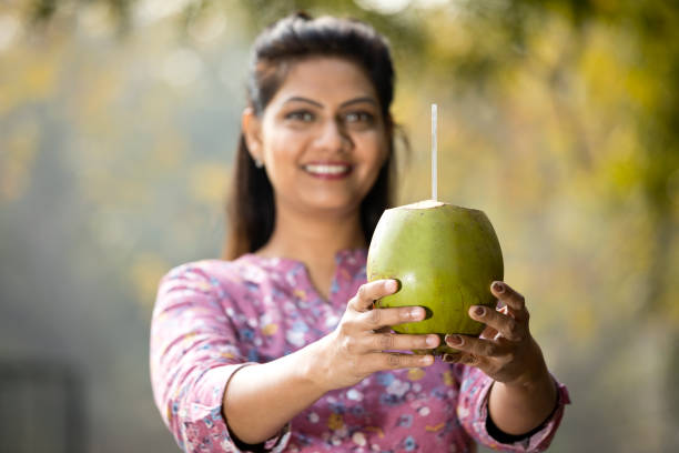 istock Woman drinking coconut water at park 1205339091