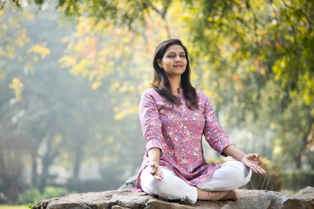 istock Beautiful woman meditating position at park 1205339396