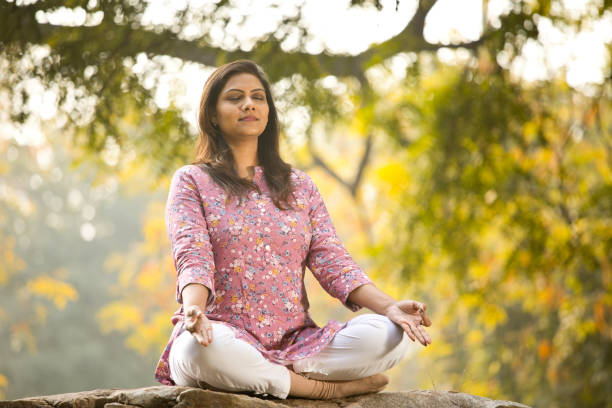 istock Beautiful woman meditating position at park 1205339462