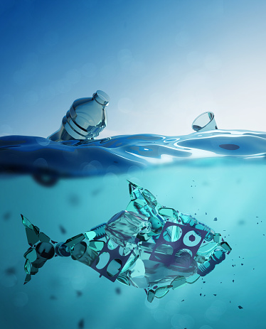 Ocean pollution concept - A fish shape made up of microplastics, plastic bags and waste in the open ocean. 3D illustration.
