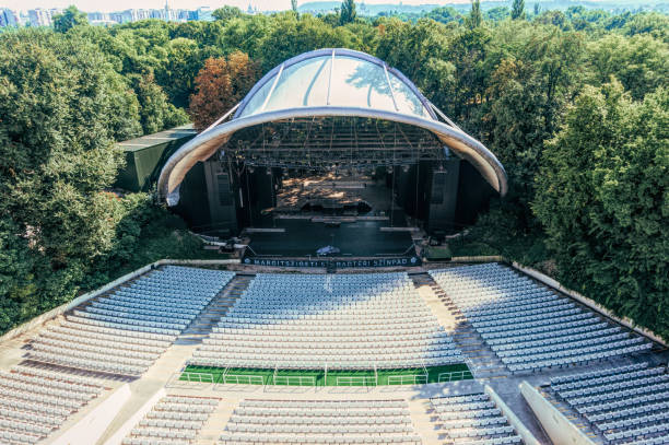 Empty seats of a summer open concert hall Budapest, Hungary - August 29, 2019: Stage under the dome and seats of the summer concert hall in a city park on Margaret Island in Budapest, Hungary. Summer holidays and music concerts in the capital of Hungary margitsziget stock pictures, royalty-free photos & images