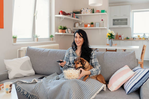 istock Woman sitting on the couch take some good time with her dog 1205342635