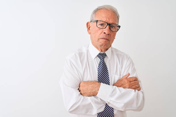 senior grey-haired businessman wearing tie and glasses over isolated white background skeptic and nervous, disapproving expression on face with crossed arms. negative person. - businessman business arms crossed business person imagens e fotografias de stock
