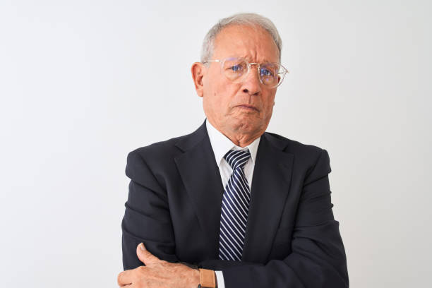 senior grey-haired businessman wearing suit and glasses over isolated white background skeptic and nervous, disapproving expression on face with crossed arms. negative person. - businessman business arms crossed business person imagens e fotografias de stock