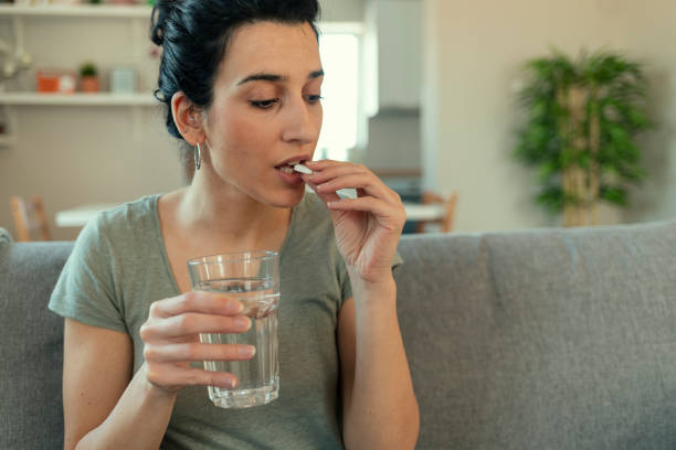 istock Young Woman Taking a Pill 1205344326