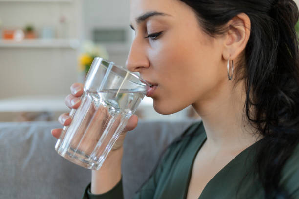 istock Woman Drinking Glass of Water 1205344996