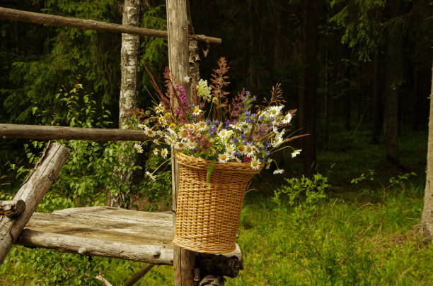 istock Flower basket in the forest hanging on wooden poles 1205345708