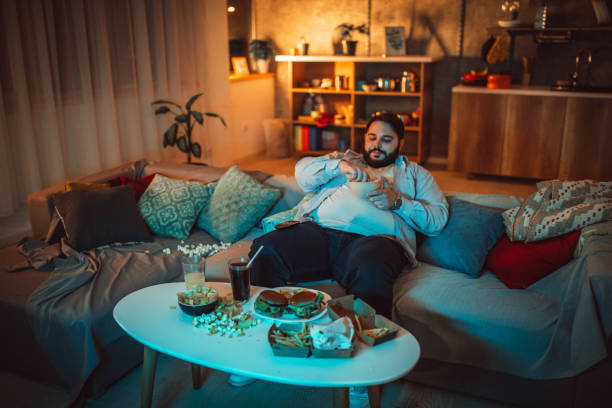 istock Fat man eating fast food 1205346928