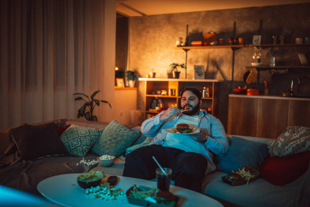 istock Fat man eating fast food 1205347015