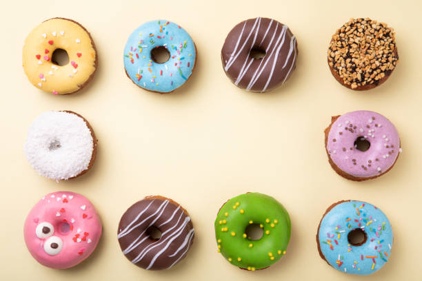 istock Top view of set of donuts on yellow background. Flat lay, copy space. 1205347021