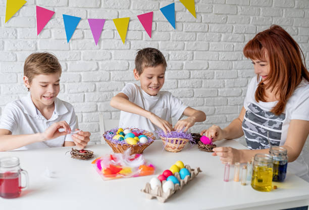 istock Happy family making Easter craft coloring eggs 1205348395
