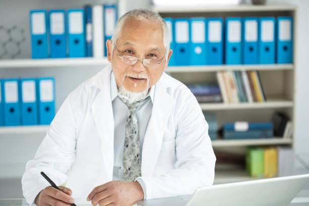 Medical specialist using laptop in cabinet