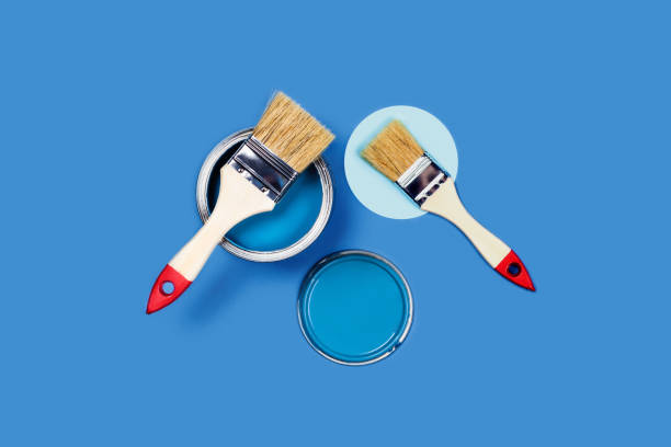 istock Colored background with paint jars and brush. 1205350980