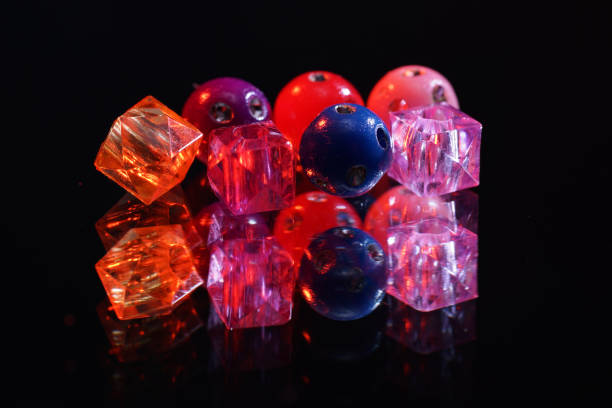 istock Colorful glass beads on mirrored surface photographed in studio 1205351339