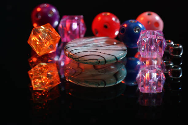 istock Colorful glass beads on mirrored surface photographed in studio 1205352680