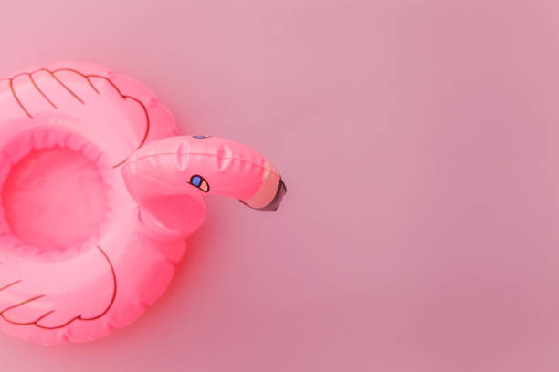 istock Summer beach composition. Simply minimal design with Inflatable flamingo isolated on pastel pink background. Pool float party, trendy celebrity fashion concept. Flat lay top view copy space 1205353335