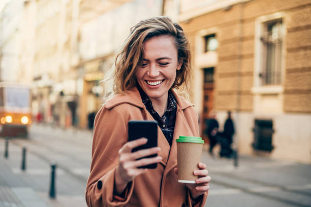 istock Cheerful woman using smart phone in the city. 1205353555