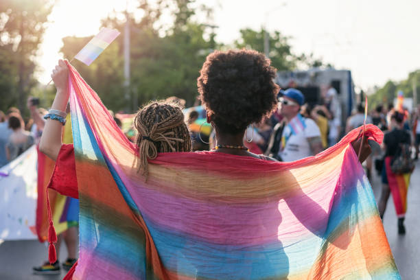 istock Female couple walking with the pride parade 1205354871
