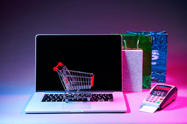 istock Laptop with custumers trolley, gift packet, and pin pad on the table in modern neon colors. 1205354875