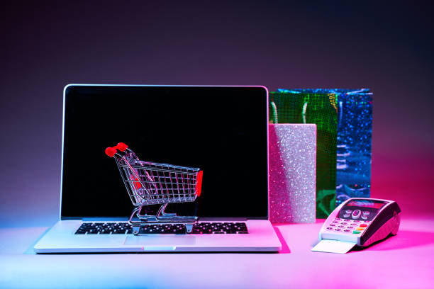 istock Laptop with custumers trolley, gift packet, and pin pad on the table in modern neon colors. 1205355453