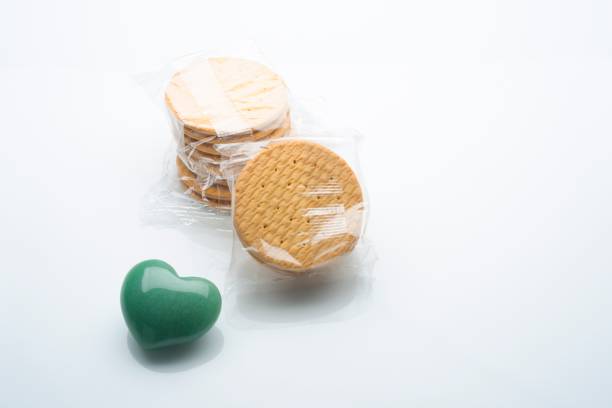 Image made in studio over white background with a heart shape green stone and gluten free cookies. Image made in studio with a Nikon D610 full frame sensor size .
