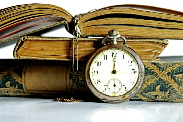 An old pocket watch and antique books