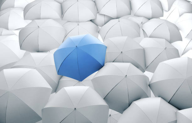istock Blue umbrella in mass of white umbrellas. 1205359198