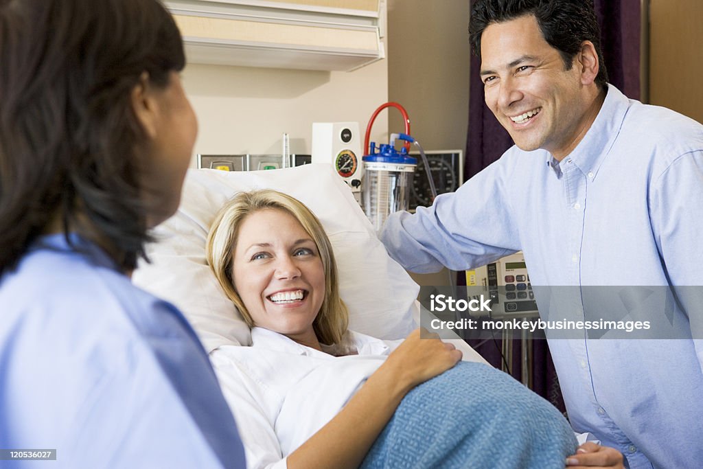 Medico parlando con donna incinta e suo marito - Foto stock royalty-free di Donne