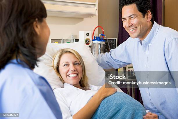 Doctor Talking To Pregnant Woman And Her Husband Stock Photo - Download Image Now - Hospital, Pregnant, Women